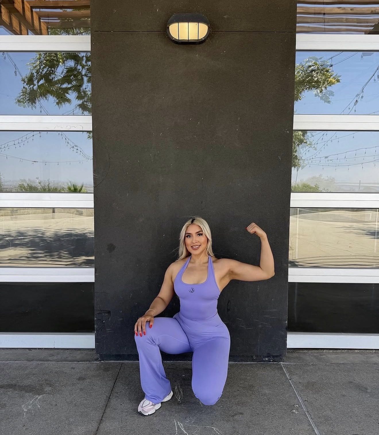 Emily Sanchez crouching in a purple matching set